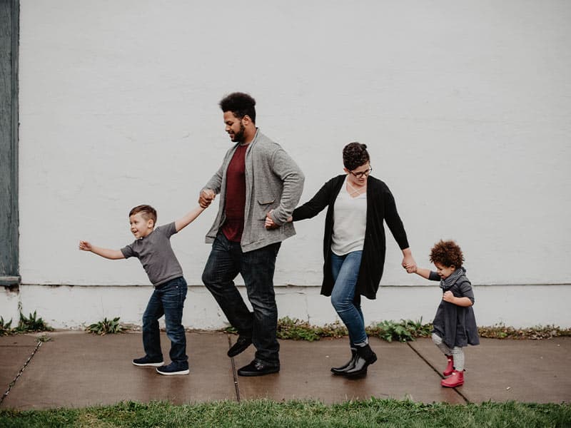 family of four walking in the rain