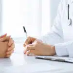 doctor sitting with patient explaining medication assisted treatment for alcoholism